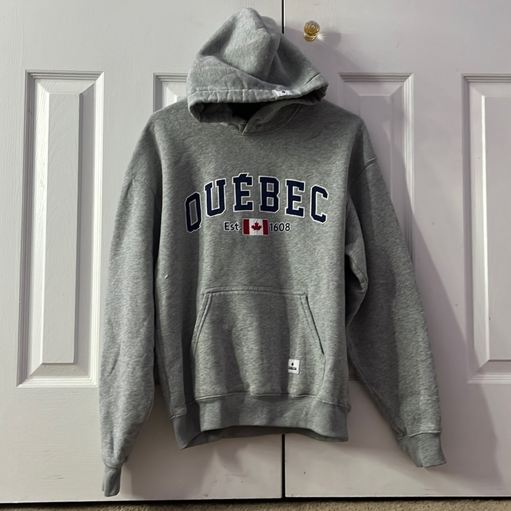 Small gray sweatshirt. Quebec writing.